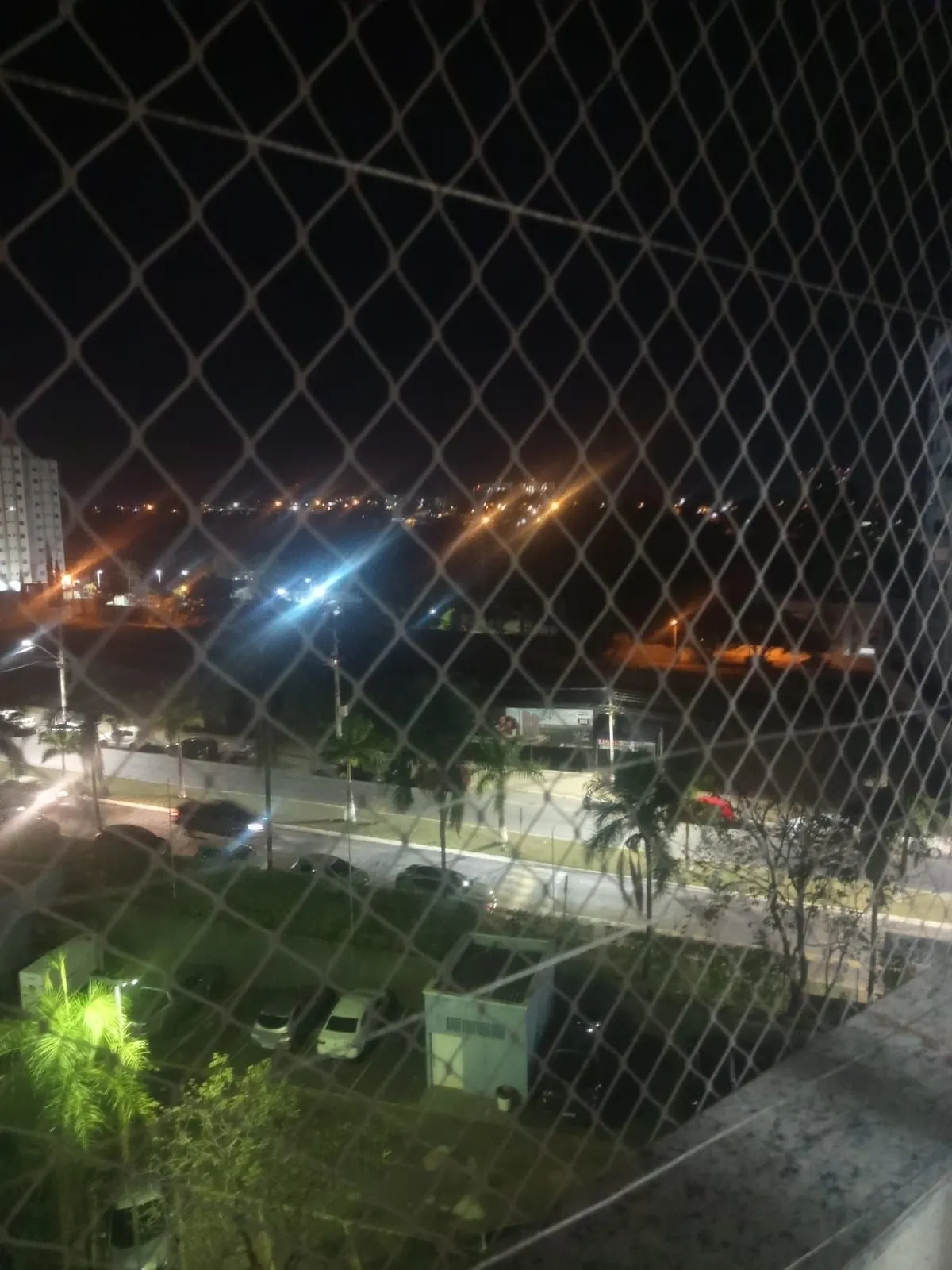 Vista noturna a partir da varanda, com tela de proteção