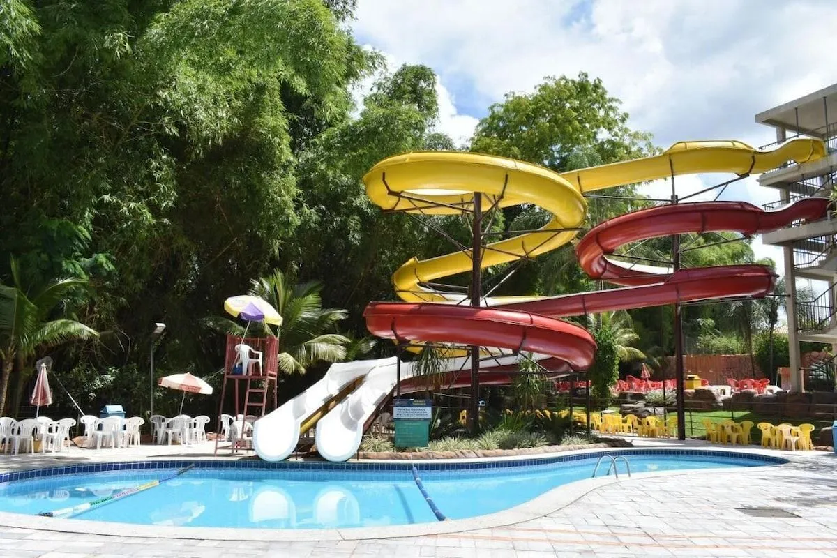 Piscina com toboáguas coloridos na área de lazer do clube