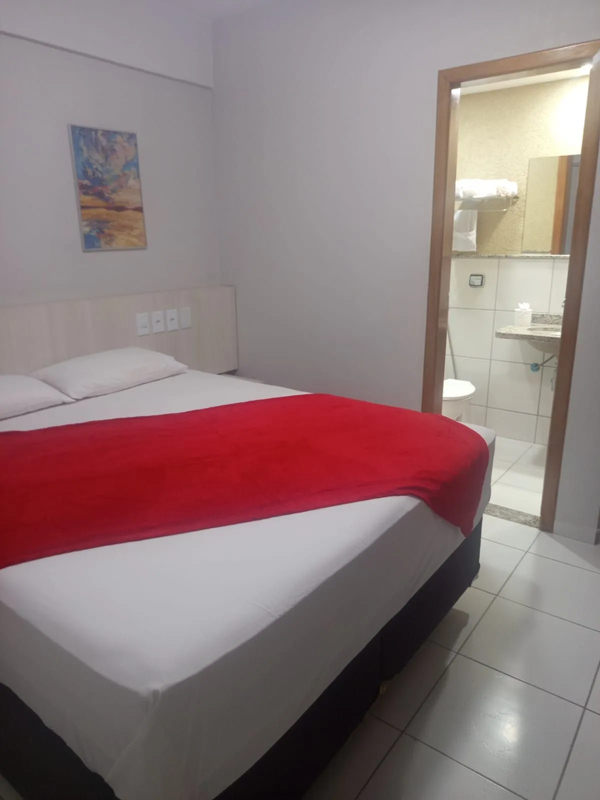 Quarto com cama de casal e porta para o banheiro